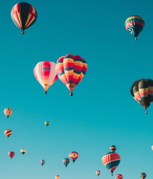 Several hot air balloons in a blue Albuquerque sky