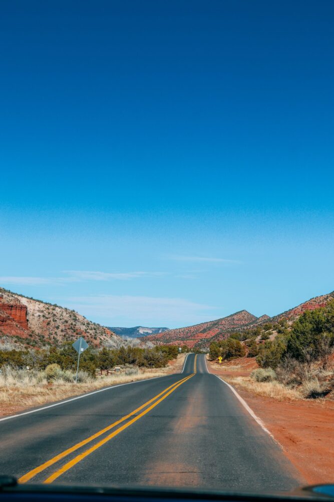 Long road leading into a desert mountain landscape